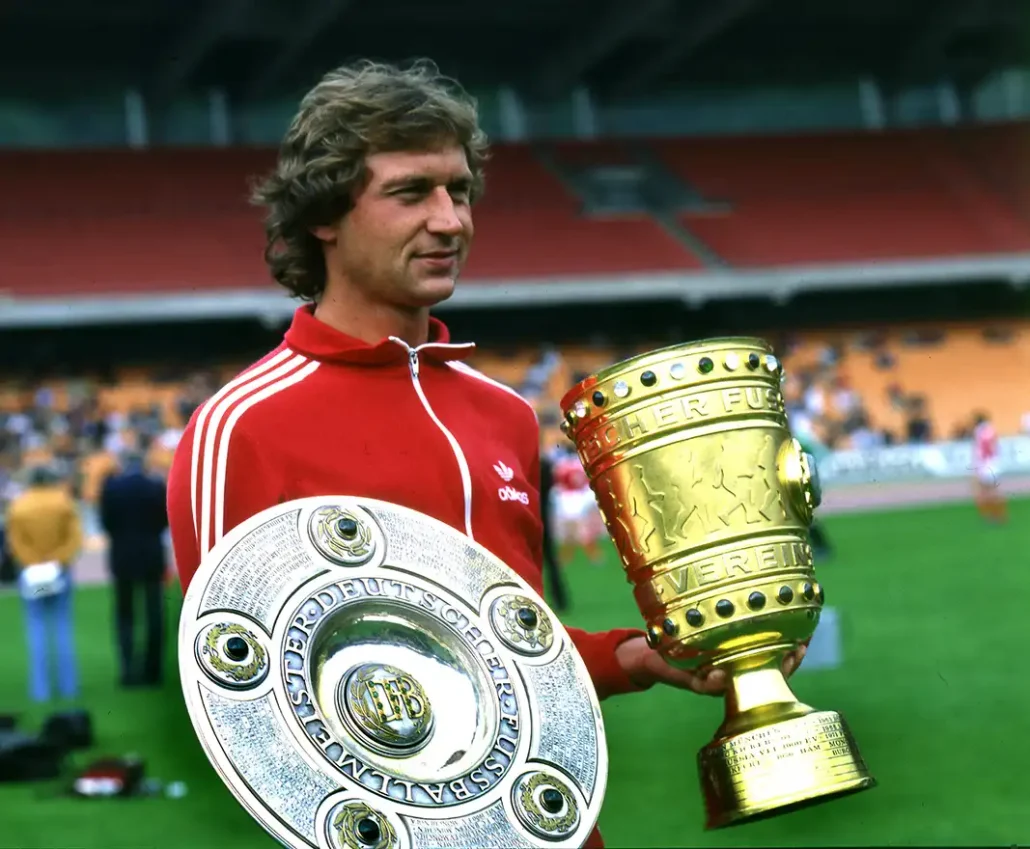 Heinz Flohe nach der Saison 1977/78 mit Meisterschale und DFB-Pokal - im Outfit des FC-Ausrüsters Adidas. (Foto: IMAGO / Horstmüller)