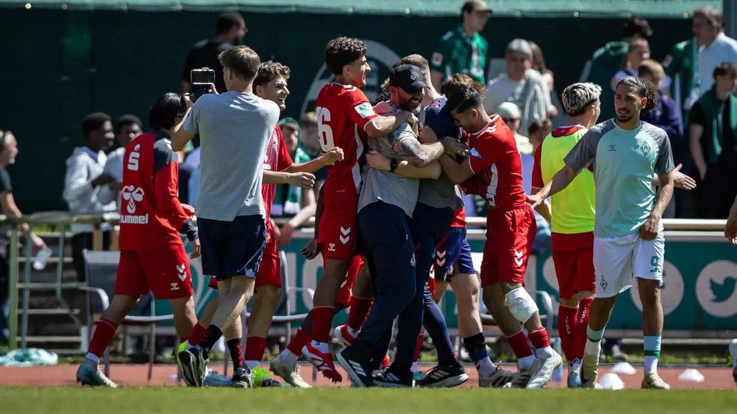 U19-Trainer Stefan Ruthenbeck mitten in der Jubeltraube. (Foto: IMAGO / Beautiful Sports)