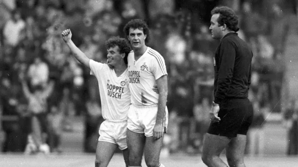 Wolf Haas und Gerd Strack jubeln um Trikot des 1. FC Köln.